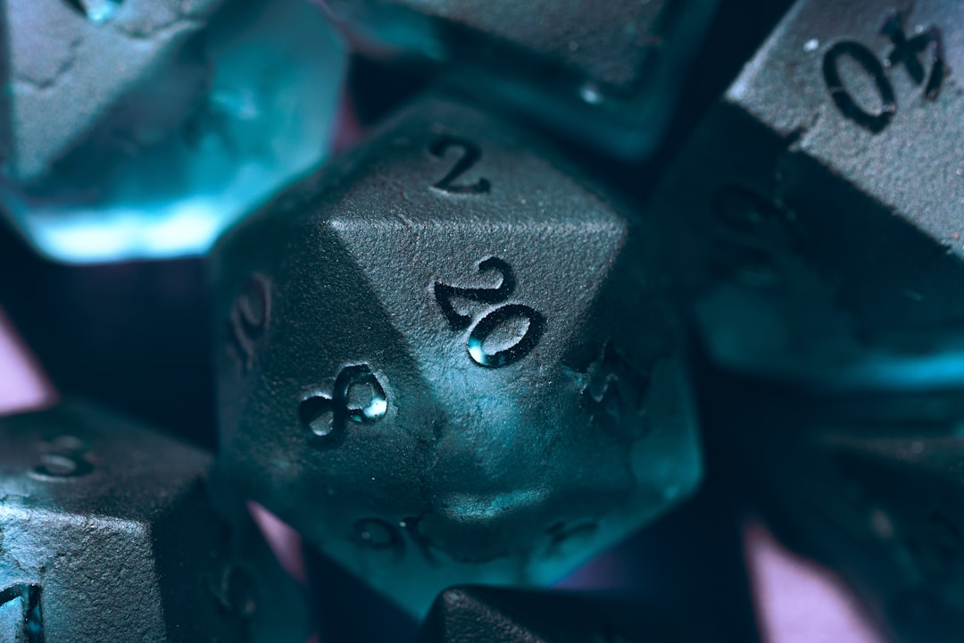A blue d20 gaming dice sitting in a purple box with the 20 facing up.